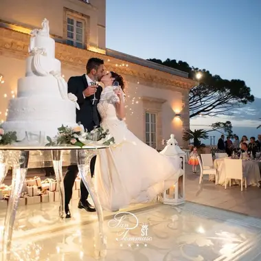 Sposi che si baciano accanto alla torta nuziale