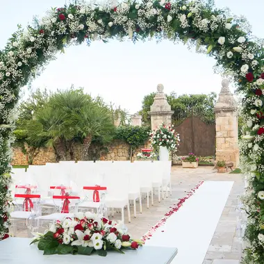 Arco floreale e navata di una cerimonia all'aperto