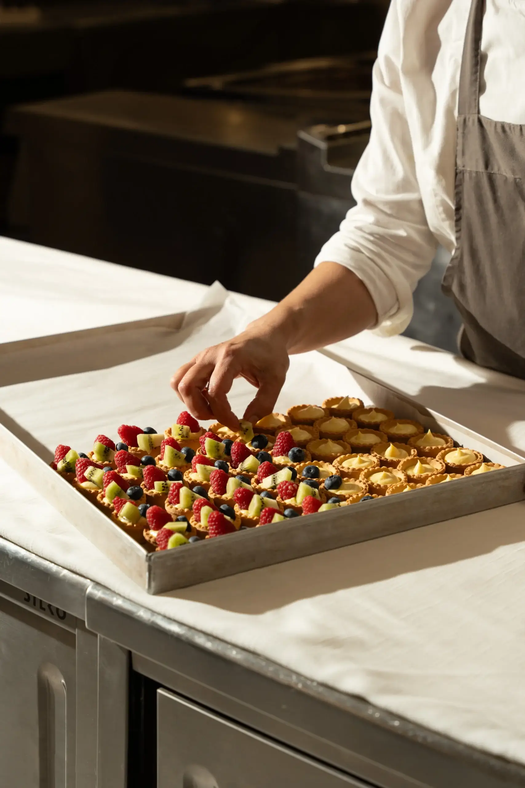 Pasticcere che prepara una teglia di finger food